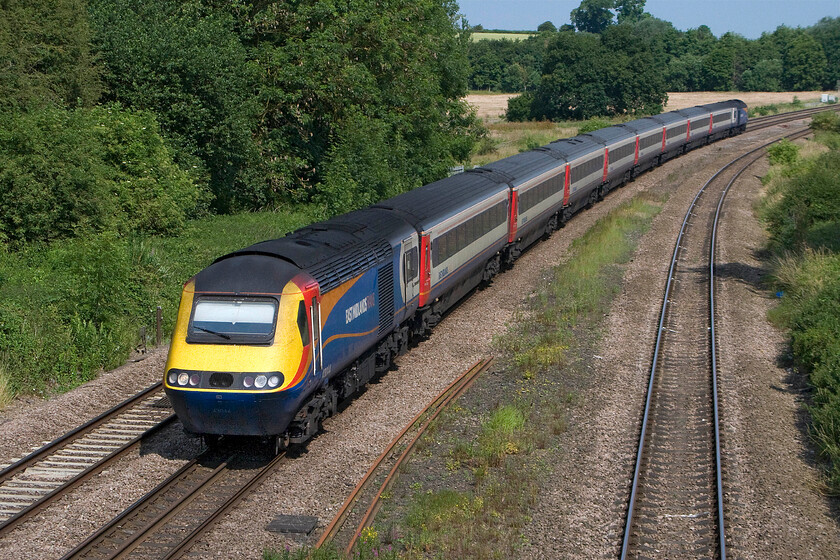 43044, EM 09.32 Nottingham-London St. Pancras (1B28), Finedon Road industrial estate SP900702 
 I cannot help but wonder as to how the driver of HST power car 43044 can see to drive the train! With the sunblind almost extended completely to the base of the windscreen, the 09.32 Nottingham to St. Pancras service approaches Wellingborough taken from a footpath that crosses a small bridge near to the Finedon Road industrial estate. This power car was a Western Region unit delivered back in 1976 as part of set 253022. 
 Keywords: 43044 09.32 Nottingham-London St. Pancras 1B28 Finedon Road industrial estate SP900702 East Midlands HST