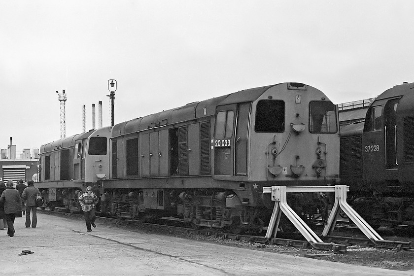 20081, 20033 & 37228, Crewe Works 
 A pair of class 20s, numbers 20081 and 20033 await attention at Crewe Works. At the rear is 20083 that is still with us to this day. Whilst, at the time of writing, it is not actually in-service it survives as 20903 stored at Nemesis Rail's Burton-on-Trent facility. In the foreground is 20033 that has obviously met with an unfortunate accident given the angle of its cab. This damage precipitated its withdrawal as, within two weeks of this picture being taken, the famed railway photographer John Chalcroft took an image of the locomotive in two halves with all but its superstructure remaining at Crewe. Notice that both the 20s in this image retain their tablet catcher equipment recesses under the TOPS numbers. Behind the 20s is 37228 that is receiving attention at the works. It went on to become 37696 in 1996 and was until recently still with us, all be it stored and in a shocking state. I have seen it at both Long Marston and Derby's RVEL facility. 
 Keywords: 20081 20033 37228 Crewe Works