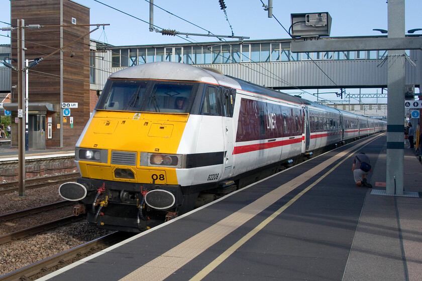 82208, GR 07.15 Leeds-London King's Cross (1A09, 2E), Peterborough station 
 DVT 82208 heads the 07.15 Leeds to King's Cross at full line speed through Peterborough station. The LNER take on the InterCity swallow livery is pretty good keeping the thirty-year-old trains looking fresh. Notice the young lad crouching down on the platform videoing the passage of the train on his 'phone. He was one of a number of youngsters around Peterborough station engaged in what we would have referred to, back in the day, as trainspotting but today seems to revolve around technology with not a single note book and pencil in sight! 
 Keywords: 82208 07.15 Leeds-London King's Cross 1A09 Peterborough station DVT