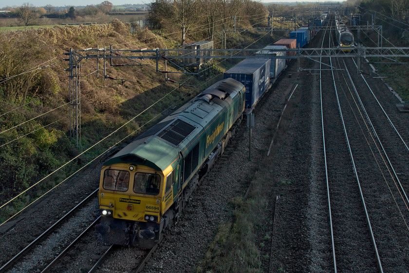 66594, 09.12 Felixstowe North-Trafford Park (4M63, 19L), Victoria bridge 
 In almost complete shade 66594 'NYK Spirit of Kyoto' passes Victoria bridge between Roade and Ashton leading the 4M63 09.12 Felixstowe to Trafford Park Freightliner train. On the down fast an Avanti West Coast Pendolino is about to race past. 
 Keywords: 66594 09.12 Felixstowe North-Trafford Park 4M63 Victoria bridge NYK Spirit of Kyoto