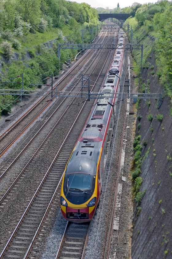 Class 390, VT 11.50 London Euston-Birmingham New Street (1G08), Roade cutting 
 With its draw gear cover partially open, doing nothing for its otherwise sleek aerodynamics a Class 390 Pendolino passes northward through Roade cutting. It is working the 11,50 London Euston to Birmingham New Street 1G08 Virgin service. 
 Keywords: Class 390 11.50 London Euston-Birmingham New Street 1G08 Roade cutting Virgin Trains West Coast Pendolino