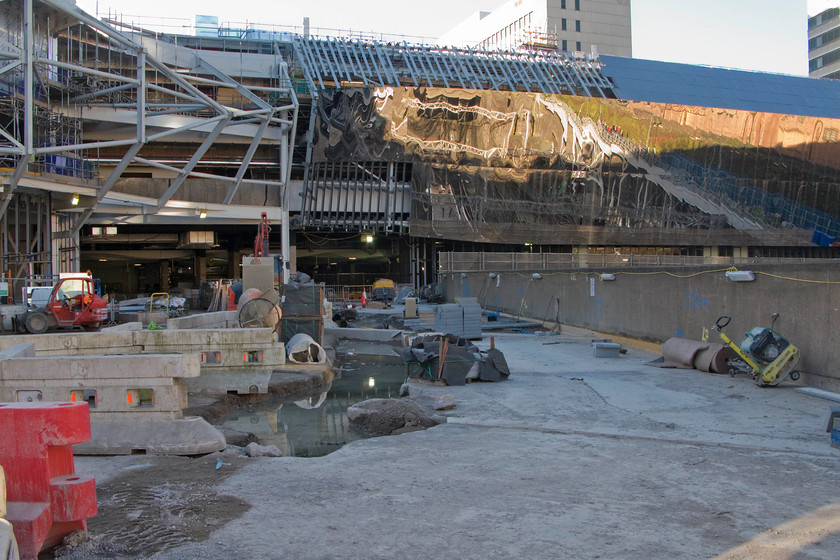 Rebuilding, Birmingham New Street station 
 An image of what will become one of the main entrances of the rebuilt Birmingham New Street. Considering that the station is due to reopen later this year, there appears to be a lot of work still to do! Security staff did not take kindly to me taking this photograph stating that they would call the police if I did not delete the image and move away. Bear in mind that I was standing in a public area and looking through a viewing space in the fence. As a fully paid-up member of the awkward squad, I was in no rush to move away and deliberately took some more pictures. 
 Keywords: Class 323 new cladding Birmingham New Street station