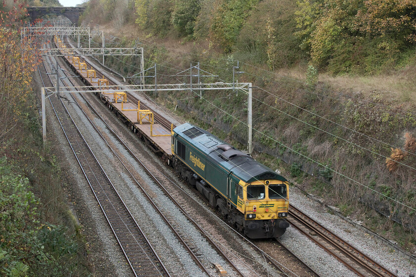 66596, 12.05 Bletchley Relief-Bescot (6Y66, 113L), Hyde Road bridge 
 Dead in tow on the rear of the 6Y66 12.05 Bletchley to Bescot engineering train 66596 is dragged through Roade cutting taken from the village's Hyde Road bridge. This train made good progress to clear the engineering blockade between Northampton and Rugby as part of the rushed efforts to open the slow lines for passenger traffic following the closure of the fast lines due to damaged catenary. 
 Keywords: 66596 12.05 Bletchley Relief-Bescot 6Y66 Hyde Road bridge Freightliner