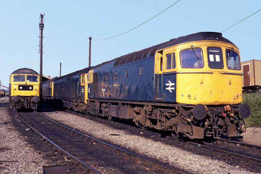 Class 37, 47341, 47160, 50015 & 33003, Westbury MPD 
 Class 37s and 47s were common on Westbury shed during this time. Not so common were Class 50s and 33s. With an unidentified Class 37 looking on in the background 47341 and 47160 bask in the spring sunshine. The latter is still in operation today as 47746 'Chris Fudge' hauling railtours for WCRC. The former did not fare so well being cut up at HNRC in the Toton training compound in February 2003. 33003 dominates the line up with 50015 'Valiant' tucked in behind. According to a member of staff at the depot, the 50 had failed and described it as being 'knackered'! 
 Keywords: Class 37 47341, 47160 50015 33003 Westbury MPD Valiant stabled