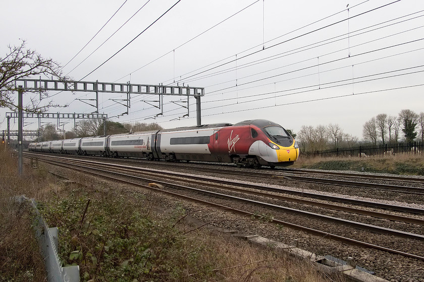 390013, VT 13.20 London Euston-Mancheste Piccadilly (1H27, RT), Ashton Road bridge 
 390013 'Blackpool Belle' is deliberately taken off-centre in this shot so as to capture, at last, the alpacas grazing in the field next to the line. I have made reference to them in several of my pictures due to their absence every time I have tried to include them. It is better to get them in a picture from the other side of the line but this will have to suffice for the moment! The Pendolino is passing between Roade and Ashton in Northamptonshire working the 13.20 Euston to Manchester Piccadilly. 
 Keywords: 390013 13.20 London Euston-Mancheste Piccadilly 1H27 Ashton Road bridge