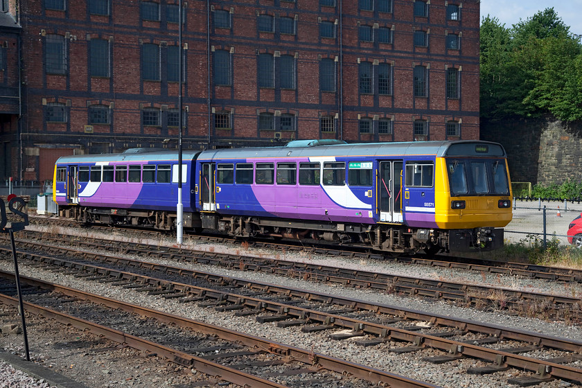 142030, stabled, Huddersfield station 
 142030 sits between duties in Huddersfield station's carriage sidings. Notice that it's still wearing its Northern Trains livery but that it's been de-branded. 
 Keywords: 142030 Huddersfield station.