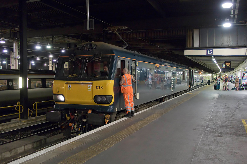 92018, CS 21.06 Wembley-London Euston sleeper ECS (5S96), London Euston station 
 92018 has just arived very late at platform 15 leading the 21.06 Wembley to Euston sleeper ECS working. The member of staff talking to the driver will soon hop down trackside and detach the 92 from the stock thus releasing the engine to return to Wembley after the train has left, its job done for the night. Despite arriving an hour late, it was still a further thirty minutes until passengers were allowed to board not long before it left at 23.45. According to CS, rooms should be available from 22.30 so this appears to be another example of how things are not going right for the operator and after talking to staff on-board the train the problems run very deep. 
 Keywords: 92018 21.06 Wembley-London Euston sleeper ECS 5S96 London Euston station