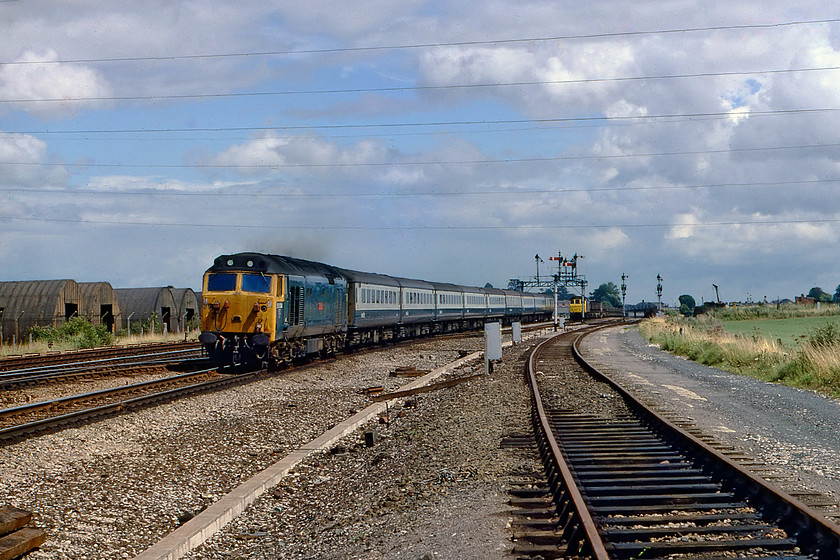 50004, 12.23 London Paddington-Penzance (1B74), Silk Mill junction 
 25121 waits for its path out of Tauntons Fairwater Yard with a down engineers train whilst 50004 'St. Vincent' races past with the 1B74 12.23 London Paddington to Penzance. This location, at the western end of Fairwater Yard, was close to Silk Mill Crossing. This was where the busy A3065 road crossed the line at the level crossing operated by Silk Mill signal box. It is good to see that the sun has finally put in an appearance! 
 Keywords: 50004 12.23 London Paddington-Penzance 1B74 Silk Mill junction