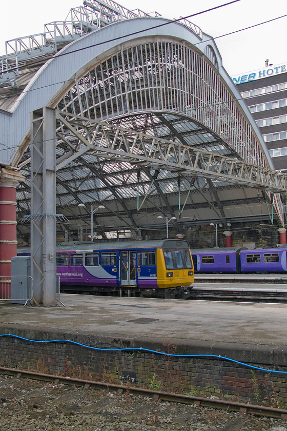 142061, NT 15.55 Liverpool Lime Street-Manchester Oxford Road (2H40), Liverpool Lime Street station 
 Lime Street station really is a gem of a structure being designed collaboratively by the architects John Cunningham, Arthur Holme, and John Foster Jr. Under one of its earlier cast-iron arches, Pacer 142061 departs with the 2H40 15.55 to Manchester Oxford Road. 
 Keywords: 142061 15.55 Liverpool Lime Street-Manchester Oxford Road 2H40 Liverpool Lime Street station Northern Trains Pacer