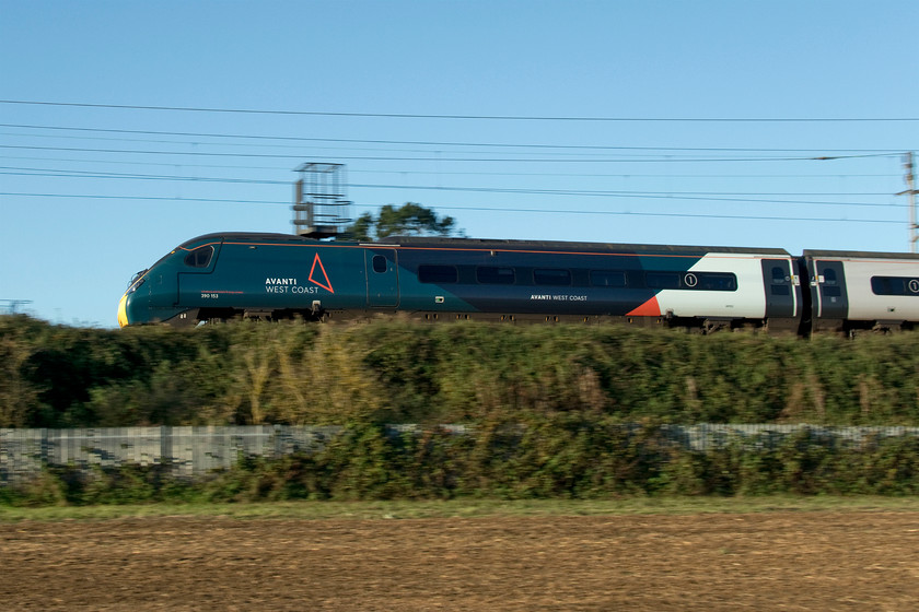 390153, VT 07.20 London Euston-Manchester Piccadilly (1H09, 4L), Milton Crossing 
 With the sun in a tricky position in the early morning at this time of year, I had very limited opportunities to photograph trains on my local WCML. As a result, I decided to go for pan shots taken from a recently ploughed field near to Milton Crossing between Roade and Blisworth. When taking pan shots I have learnt by trial and error over the years to position myself a lot closer to the subject than I initially think is right. So I stand where I think is right and then go some distance closer and hope for a 'trial' train to pass to check my positioning. I have also learnt that using a very slow shutter speed is not always needed and that it can induce an unwanted level of blur in not only the background but also the subject. This image used 1/250th second that is usually about right. 390153 is seen at the rear of the 07.20 Euston to Manchester 1H09 service. 
 Keywords: 390153 07.20 London Euston-Manchester Piccadilly 1H09 Milton Crossing