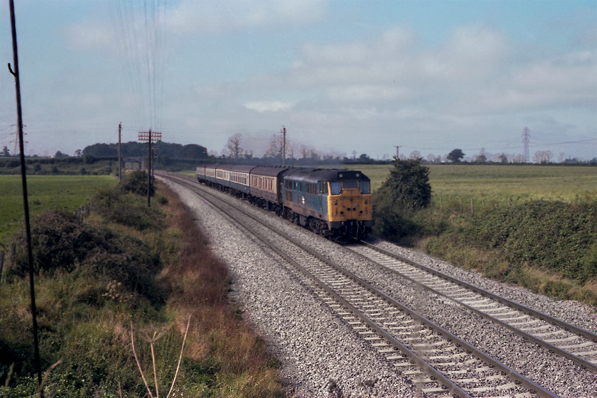 31294, unidentified Weymouth-Bristol Temple Meads working, Berkley ST805497 
 31294 leads a Weymouth to Bristol Temple Meads working past Berkeley near to Frome, where it will have diverged from the mainline and stopped for passengers. 31294 was probably one of my most regularly seen class 31s. It arrived from the Midland Region in 1972 being based at Bristol Bath Road until its withdrawal in 2000. It was cut up three years later in Stockton by T. J. Thomson and son. This scene is still very similar today except for the eastern expansion of Frome making its presence noted, see..... https://www.ontheupfast.com/p/21936chg/30019959523/x2-59202-07-12-merehead-acton-tc 
 Keywords: 31294 Weymouth-Bristol Temple Meads working Berkley ST805497