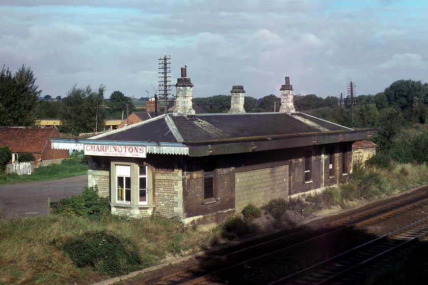 Former Aynho station 
 Often referred to as Aynho for Deddington or sometimes Aynho Lower to avoid confusion with the nearby Aynho Park Platform (on the Chiltern route), the former station that was correctly named Aynho is seen from the B4031 road bridge that spans the GWR route from Banbury to Oxford. The building is an Elizabethan styled structure known by Brunel as a 'roadside' station that found great favour with the railway company with several versions of it found throughout their vast network. The station closed in March 1964 but in this 1980 view, the building is looking a little run-down and in use by a solid fuel company. Today, it is looking in a better state now a private residence with a well-kept garden surrounding it. 
 Keywords: Former Aynho station