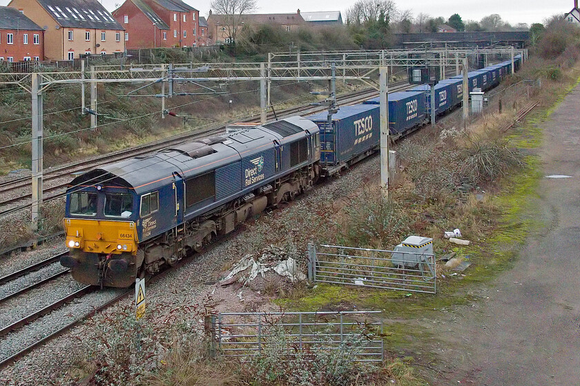 66434, 13.37 DIRFT-Tilbury (4L48, RT), site of Roade station 
 Having seen the incoming 4M07 Tesco Express a little earlier its balancing working the 4L48 13.27 Daventry (DIRFT) to Tilbury Docks is seen also passing Roade in the opposite direction to the previous photograph. The train is led by DRSs 66434 which is not one of the most common of their fleet when it comes to photographs in my collection. 
 Keywords: 66434 13.37 DIRFT-Tilbury 4L48 site of Roade station Tesco Express