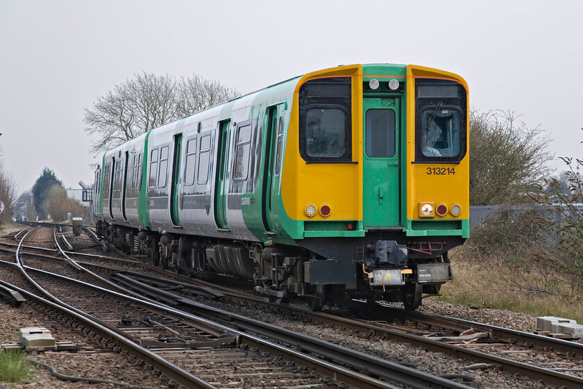 313214, 13.03 Brighton-Portsmouth Harbour, New Lane level crossing, Havant 
 Soutern's 313214 approaches Havant working the 13.03 Brighton to Portsmouth Harbour 'Coastway' service. With my back to New Lane level crossing the former L&SWR route towards Guildford via Haslemere can be see curving off to the left. 
 Keywords: 313214 13.03 Brighton-Portsmouth Harbour, New Lane level crossing Havant Southern