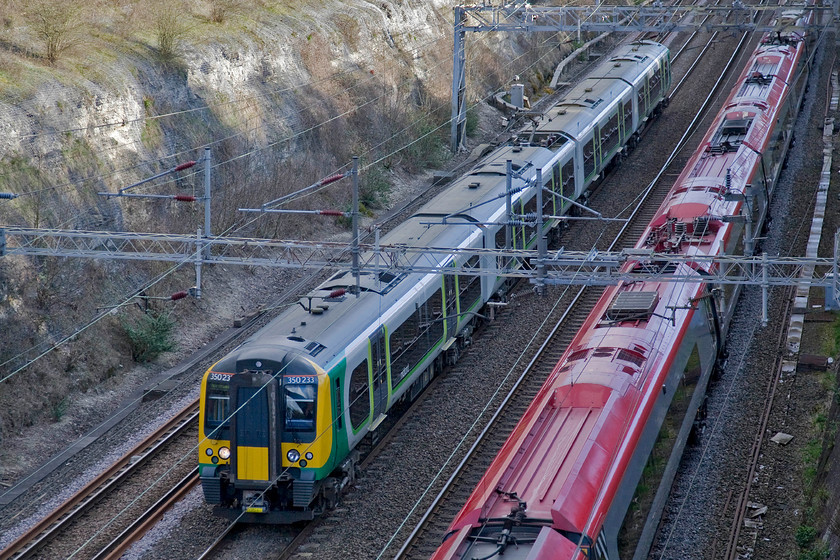 Class 390, VT 15.20 London Euston-Manchester Piccadilly (1H33) & 350233, 14.54 London Euston-Northampton (2N19), Roade cutting 
 The race is on in Roade cutting! The Class 390 Pendolino will be winning as it is on the down fast line and heading off on the Weedon loop towards Rugby as the 1H33 15.20 Euston to Manchester Piccadilly. No doubt going considerably slower is London Midland's 350233 forming the 14.54 Euston to Northampton. 
 Keywords: Class 390 15.20 London Euston-Manchester Piccadilly 1H33 350233 14.54 London Euston-Northampton 2N19 Roade cutting Virgin Pendolino London Midland Desiro