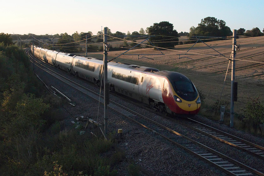 Class 390, VT 06.16 London Euston-Manchester Piccadilly (1H06, 3L), Blisworth 
 The first railway picture taken with the new Canon GX1 Mk. III, an unidentified class 390 forming the 06.16 Euston to Manchester Piccadilly passes Blisworth in Northamptonshire. This picture illustrates the capabilities of the new camera, a much increased dynamic range meaning there is good exposure and detail in the dark foreground whilst the very light sky still retains some colour and is not too burnt out. And, despite it exposing at 2000ISO there is very good rendition of noise, even though I have given it a bit of Neat Image treatment. 
 Keywords: Class 390 1H06 Blisworth