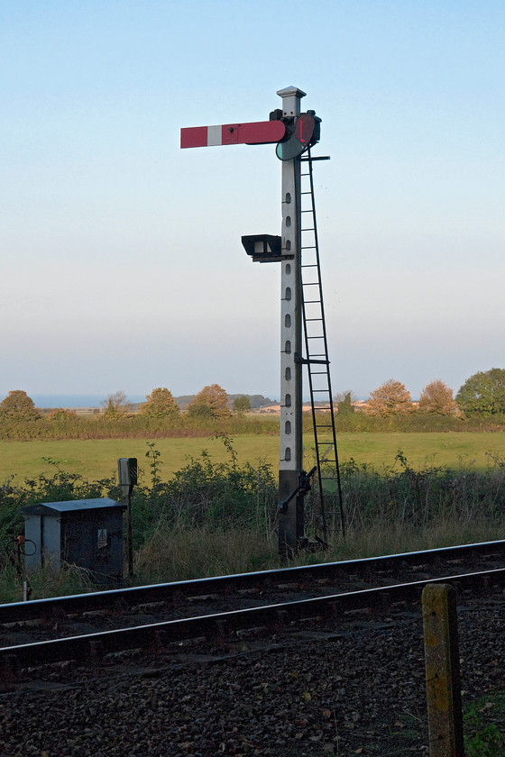 6. Up home signal, Weybourne 
 Walking back to our caravan that is located on Kelling Heath, the path goes along the side of the North Norfolk Railway. Just west of Weybourne station the railway's up home summersault signal that sits on top of a typical slotted concrete post. Notice the route indicators on the post simply telling the driver if the train is routed into platform one of two of Weybourne station. 
 Keywords: Up home signal Weybourne