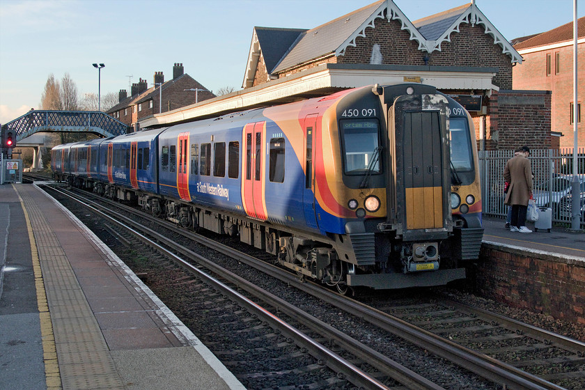 450091, SW 13.09 London Waterloo-Portsmouth Harbour (1T37, RT), Cosham station 
 Just catching some late afternoon sunshine between some tall buildings, 450091 arrives at Cosham station working the 13.09 Waterloo to Portsmouth Harbour. When Cosham station opened in 1848 it served a small and isolated village that has now been comprehensively consumed into the urban sprawl that is Portsmouth. 
 Keywords: 450091 13.09 London Waterloo-Portsmouth Harbour 1T37 Cosham station South Western Raiway SWR