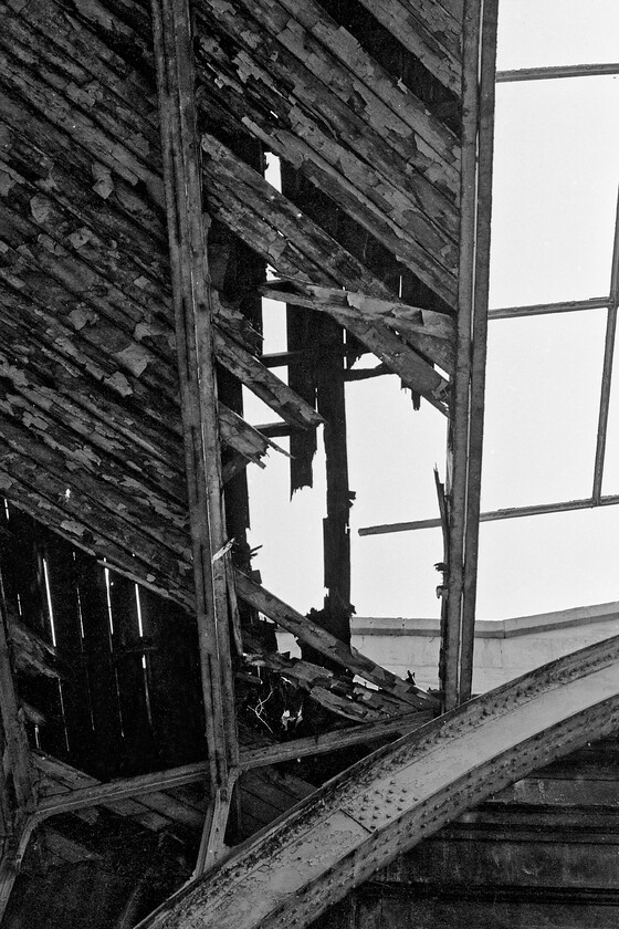 Roof, Bath Green Park station 
 The roof of Bath Green Park station is in a very poor state as seen in this photograph. The timbers are completely rotten with much having fallen through and now laying on the equally rotten timber platform below! When the rather grand station was restored in the two years or so after this photograph was taken only the wrought ironwork and the stone building were retained with everything else removed and replaced. 
 Keywords: Roof Bath Green Park station