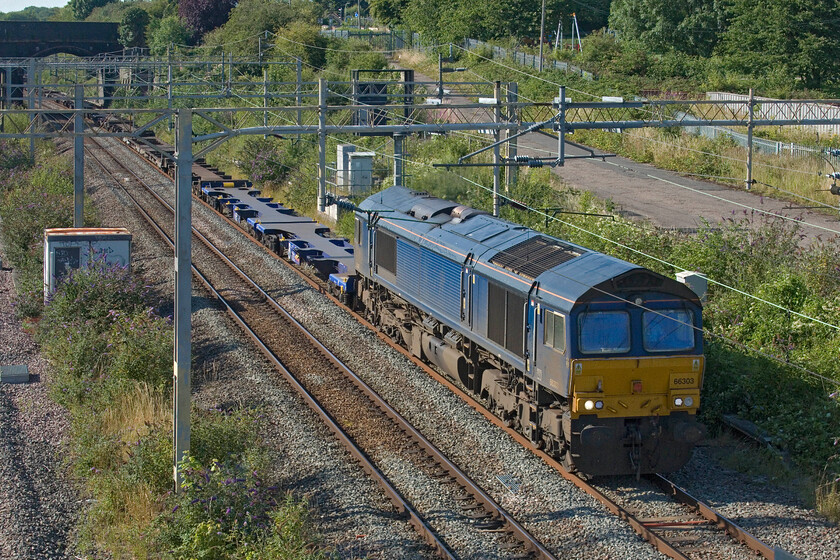 66303, 15.44 Hams Hall-Southampton Western Docks (4O32, 38L), site of Roade station 
 With the continued closure of the line through Oxford due to issues with the construction of the new under-bridge on Botley Road freight is being diverted via the already pretty congested WCML. 66303 leads the 4O32 15.44 Hams Hall to Southampton Western Docks service through Roade on this warm late July evening. 66303 is one of just five 66/3s originally ordered by Fastline that are now operated by GBRf but note that this example has no branding applied. 
 Keywords: 66303 15.44 Hams Hall-Southampton Western Docks 4O32 site of Roade station