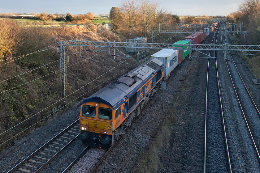 66759, 10.46 Felixstowe North-Hams Hall (4M23), Victoria bridge 
 Under a dramatic early winter sky, 66759 'Chippy' leads the 10.46 Felixstowe to Hams Hall Freightliner working. It is seen passing Victoria bridge in south Northamptonshire. This working was the fourth that passed this spot in 45 minutes and goes to show how busy the WCML can be; HS2 anybody? 
 Keywords: 66759 10.46 Felixstowe North-Hams Hall 4M23 Victoria bridge