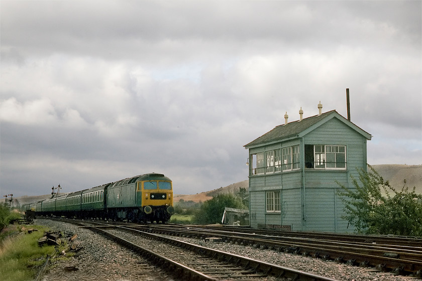 47497, 09.48 London Paddington-Newquay (1B48), Heywood Road Junction 
 A lovely shot of 47497 hauling a uniform set of Mk. I stock past Heywood Road Junction signal box about to take the down fast cut-off line. As its a set of Mk. I stock it was probably going to be a relief or a train to Newquay. Indeed, this particular one was down in Heywood Road boxs train register as the 1B48 09.48 Paddington to Newquay. The signal box here is a GW Type 28B design built of timber probably because of its precarious position on an embankment. It was opened in 1933 at the same time as the cut-off and closed when the Westbury PSB was opened in April 1984. 
 Keywords: 47497 09.48 London Paddington-Newquay 1B48 Heywood Road Junction