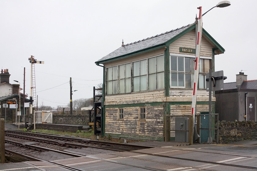 Valley Signal Box (LNWR, 1904) 
 Valley signal box looking a bit in need of a paint sits in the gloom of an April day. It still controls a number of semaphores and the associated facility used for the loading and unloading of nuclear flasks from Wylfa nuclear power station before it closed in 2013. The signal box was built by the LNWR in 1904 and, due to its originality, is now grade II listed. It still uses its as-built frame and levers. 
 Keywords: Valley Signal Box (LNWR, 1904)