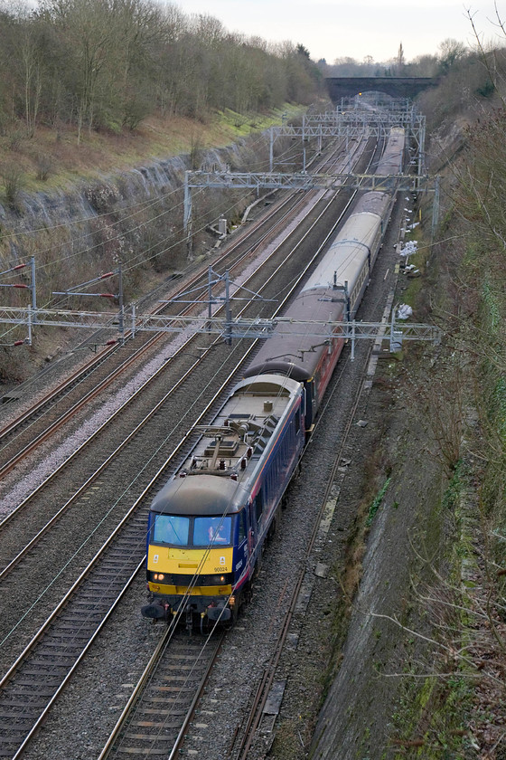 90024, 11.52 London Euston-Manchester Piccadilly Footex (1Z90), Roade cutting 
 90024 leads a mixed bag of stock through Roade cutting. The locomotive is leading the 11.52 Euston to Manchester Piccadilly football special conveying Chelsea supporters for their premier league match with Manchester United. The match was a bit of a damp squib with a resultant and not unexpected 0-0 scoreline with United being the marginally better team of the two. 
 Keywords: 90024 11.52 London Euston-Manchester Piccadilly Footex 1Z90 Roade cutting