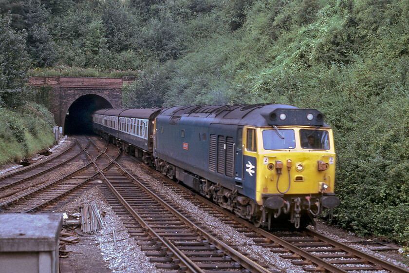 50013, 11.43 Exeter St. David's-London Waterloo (1O12), Salisbury Tunnel Junction 
 Having stopped at Salisbury, climbed away from the station and passed through Fisherton tunnel 50013 'Agincourt' bursts into the daylight and takes the 'mainline' towards Andover, Basingstoke and London. The unrefurbished Class 50 is leading the 1O12 11.43 Exeter to Waterloo service and is photographed from the end window of Salisbury Tunnel Junction's signal box. Notice the absence of signalling at this spot caused by the close proximity of the junction and the tunnel. To get around this problem Salisbury East boxs starting signal was slotted to act as the junction signal. For down trains from both London (the mainline) and Dean (the 'Branch') signals were easier to place in more conventional locations. The spot seen in this photograph was where the collision took place between two trains on the night of 31.10.21 finding a GWR and SWT unit crushed together just inside the entrance to the tunnel with the latter almost on its side. The cause was, after much-ill-informed tittle-tattle fueled by members of the media and railway officials who should have known better, found to be an uncontrolled slide of a mile or so caused by leaf railhead contamination. This was due to this section of the track missing out on the last scheduled leaf-busting train. 
 Keywords: 50013 11.43 Exeter St. David's-London Waterloo 1O12 Salisbury Tunnel Junction