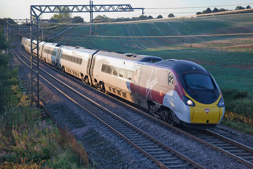 390044, VT 06.20 London Euston-Birmingham New Street (9G02, 2L), Milton crossing 
 A classic glint-shot at Milton crossing at 06.50 on a glorious September morning. The sun's early morning rays just catch the side of 390044 as it works the 06.20 Euston to Birmingham New Street. 
 Keywords: 390044 06.20 London Euston-Birmingham New Street 9G02 Milton crossing