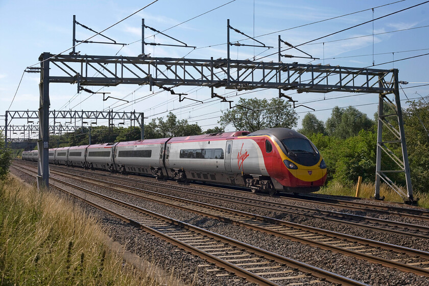 390136, VT 09.40 London Euston-Manchester Piccadilly (1H64), Bradwell SP831391 
 390136 'City of Coventry' races past Bradwell in Milton Keynes with the Virgin 09.40 Euston to Manchester Piccadilly service. This bucolic scene belies the fact that this location is in the middle of Milton Keynes surrounded by houses and industry. However, it does illustrate one of the founding tenets of the new town planning should be a green and pleasant place to live separating housing, work and leisure; in many ways, it has succeeded in this. 
 Keywords: 390136, VT 09.40 London Euston-Manchester Piccadilly (1H64), Bradwell SP831391 City of Coventry