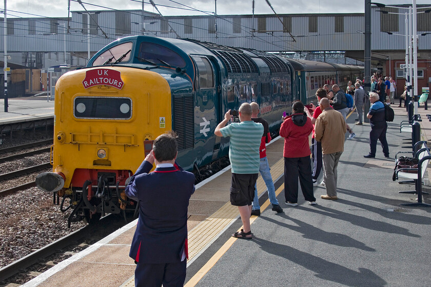 55009 (55013), outward leg of The Coronation Deltic, 07.52 London King's Cross-Scarborough (1Z55, 8L), Peterborough station 
 Peterborough station was awash with enthusiasts of every age for the arrival and departure of The Coronation Deltic charter that was postponed from 13.05.23 due to the ongoing industrial action. The DPS' 55009 'Alycidon' masquerading as 55013 'The Black Watch' slows to a halt leading the charter running, appropriately, as 1Z55. The reason for the change of identity was not just a bit of fun with the actual reason becoming clear later in the day. After setting off running on both engines from King's Cross on arrival at Peterborough one had been shut down and this remained the case for the rest of the journey. This did not prevent it from cresting Stoke summit at over ninety mph with load ten and a dead Class 47 on the rear. We also maintained ninety-five for several stretches of the line north of Retford. 
 Keywords: 55009 55013 The Coronation Deltic 07.52 London King's Cross-Scarborough 1Z55, Peterborough station Alycidon The Black Watch