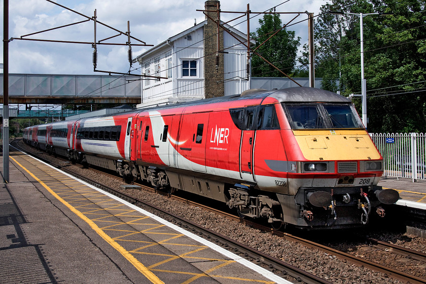 82208, GR 10.00 Edinburgh Waverley-London King`s Cross (1E10, 8L), Oakleigh Park station 
 At last, a picture in full sun! DVT 82208 is within a few miles of its destination having covered the 348 from Edinburgh with the 10.00 express. With access to the up and down fast platforms denied by railings, I leaned over them with the camera used remotely by utilising its excellent fold-out screen. Notice the elevated booking office at footbridge level. It sits a little incongruously on a narrow base that it overhangs on both sides. 
 Keywords: 82208 10.00 Edinburgh Waverley-London King`s Cross 1E10 Oakleigh Park station