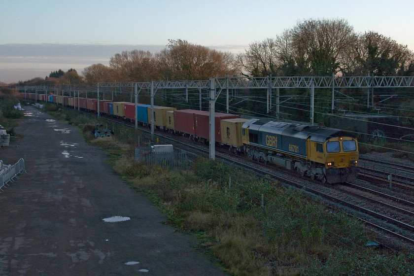 66701, 12.05 London Gateway-Hams Hall (4M46, 30L), site of Roade station 
 I didn't come out for this but for something far more interesting instead coming the other way in a few minutes time! However, I like a challenge and getting this photograph was certainly that! With the sun set below the horizon at 15.35 66701, leading the 4M46 12.05 London Gateway to Hams Hall, is in full and heavy shadow even though there is still some light in the lovely early evening sky. 
 Keywords: 66701 12.05 London Gateway-Hams Hall 4M46 site of Roade station