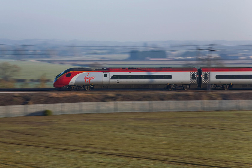 390045, VT 07.43 London Euston-Glasgow Central (1S47), Blisworth 
 By utilising a 1/80th second shutter speed I panned the camera following the front of the Pendolino in the viewfinder. The pan view of 390045 forming Virgin's 07.43 Euston to Glasgow Central results in a blurred background with the subject relatively sharp. I should have adopted this approach when taking the photograph of 86259 'Les Ross/ Peter Pan' a little earlier here at Blisworth just north of Roade cutting. 
 Keywords: 390045 07.43 London Euston-Glasgow Central 1S47 Blisworth