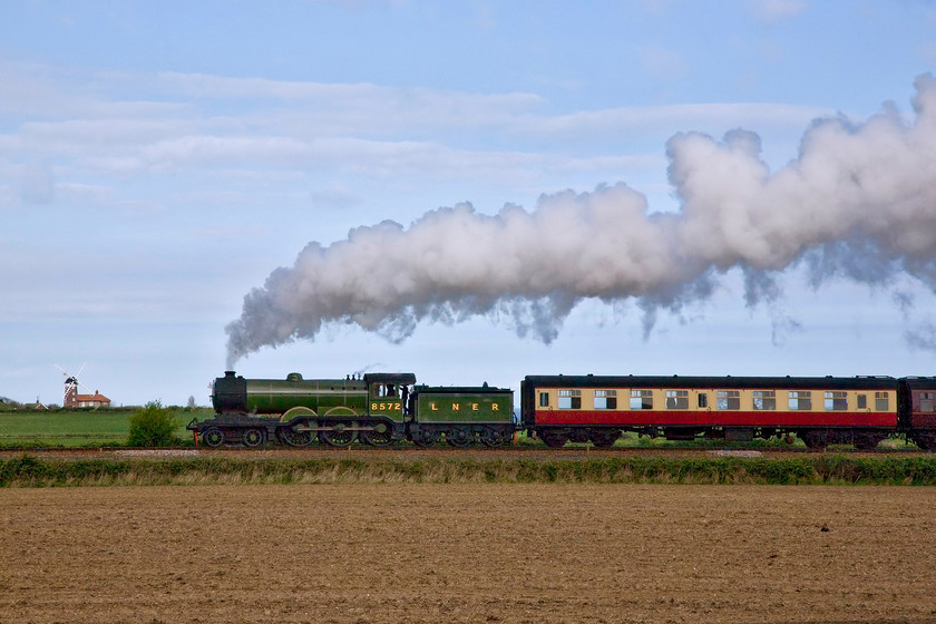 8572, 09.45 Sheringham-Holt, Weybourne Heath TG125425 
 A photograph that I have managed to salvage through Photoshop! The idea was a sound one and up to about thirty seconds before the train arrived it was coming together nicely until an errant cloud had other ideas. The side illumination of 8572 leading the 09.45 Sheringham to Holt is disappointing leaving it dark against the bright sky. It is the exhaust that has saved the day in this scene taken from Weyboune Heath with the well-known windmill in the background. 
 Keywords: 8572 09.45 Sheringham-Holt Weybourne Heath TG125425 Poppy Line NNR North Norfolk Railway LNER B12 4-6-0