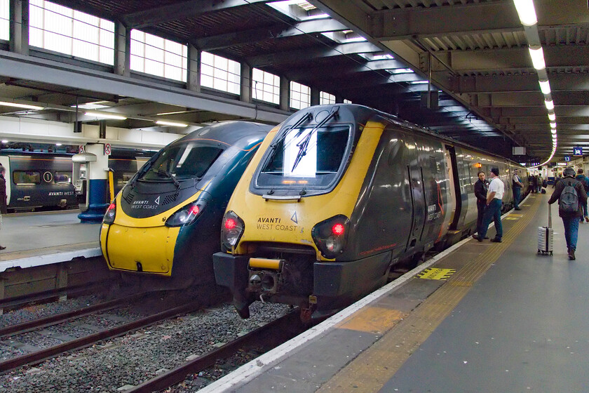 390122, VT 12.53 London Euston-Manchester Picadilly & 221114, VT 13.02 London Euston-Chester (1D87, 1L), London Euston 
 A scene that should have been banished from Euston by now! With the bi-mode Class 800s undergoing testing, crew training and mileage accumulation runs surely the removal of the the unloved Voyagers from this route is imminent. 221114 is prepared and passengers board for it to work the 1D87 13.02 Euston to Chester service. 390122 waits in the adjacent platform with the 12.53 to Manchester Picadilly. 
 Keywords: 390122 12.53 London Euston-Manchester Picadilly 221114 13.02 London Euston-Chester 1D87 London Euston