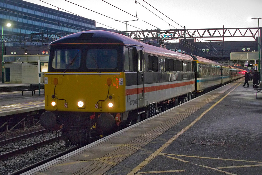 87002, outward leg of The Capital's Scot, 06.56 London Euston-Edinburgh Waverley (1Z86, 1E), Milton Keynes Central station 
 What a difference twenty minutes makes! The sky has really lightened up but the sun has yet to rise at Milton Keynes. Taken at 07.40 87002 'Royal Sovereign' arrives at the station leading The Capital Scot's charter that left Euston at 06.56 and heading for Edinburgh. This would give passengers just over two hours in the city before returning back down the ECML to King's Cross. I am not sure how those who joined at the intermediate pick-up stations (such as here at Milton Keynes) would get home? Taking the reporting number normally awarded to the regular Cumbrian Mountain/Coast Express charters this one is also running as 1Z86; it's a shame that it could not have been changed to 1Z87! 
 Keywords: 87002 The Capital's Scot, 06.56 London Euston-Edinburgh Waverley 1Z86 Milton Keynes Central station InterCity Roayl Sovereign LSL