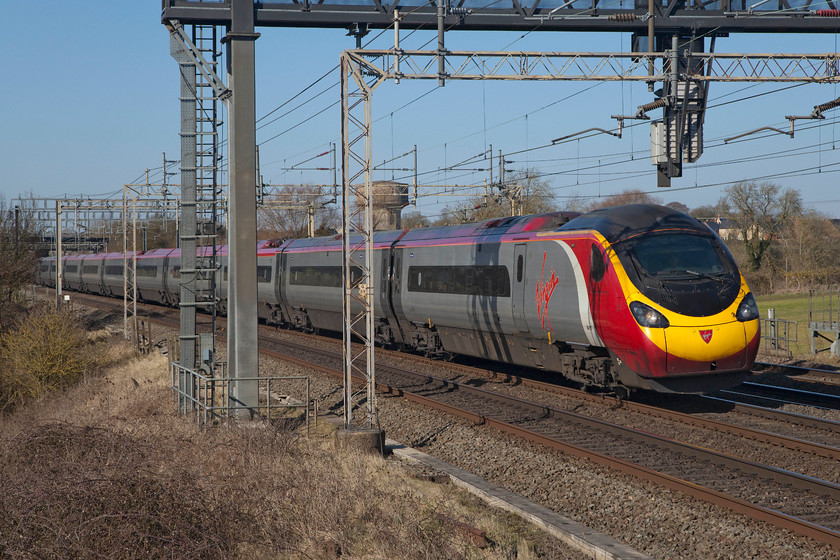 390127, VT 11.16 Manchester-London Euston (1A17, 22L), Roade Hill 
 Having got the green light, 390127 'Virgin Buccaneer' begins to ease away from its extended stop at Roade Hill on the southern WCML. It was working the 11.16 Manchester Piccadilly to Euston (1A17). Because of this hold up, it arrived at its final destination some 22 minutes late. 
 Keywords: 390127 Virgin Buccaneer 1A17 Roade Hill