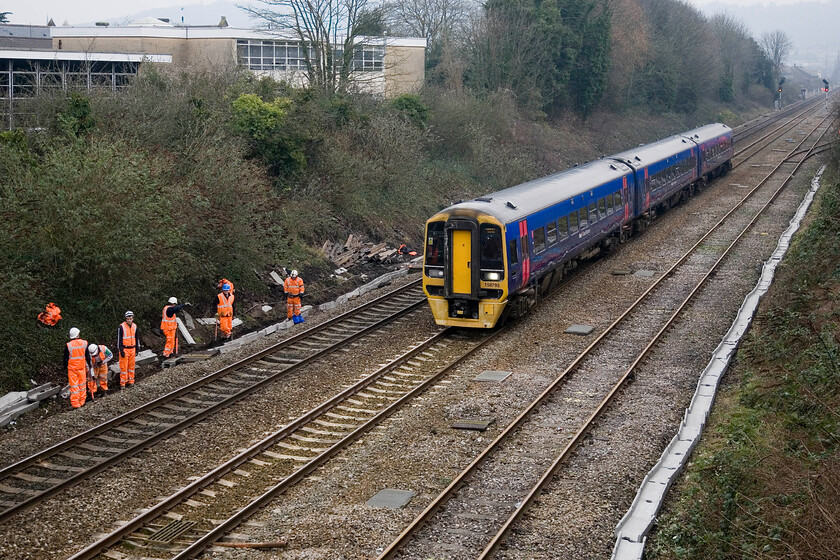 158798, GW 07.05 Portsmouth Harbour-Cardiff Central, Oldfield Park, Brougham Heyes Bridge 
 158798 working the 07.05 Portsmouth Harbour to Cardiff Central service accelerates away from its stop at Bath Spa passing Oldfield Park and several gangers involved in electrical conduit replacement. Just out of sight to the right were more orange-clad workers engaged in embankment clearance. 
 Keywords: 158798, GW 07.05 Portsmouth Harbour-Cardiff Central, Oldfield Park, Brougham Heyes Bridge First Great Western