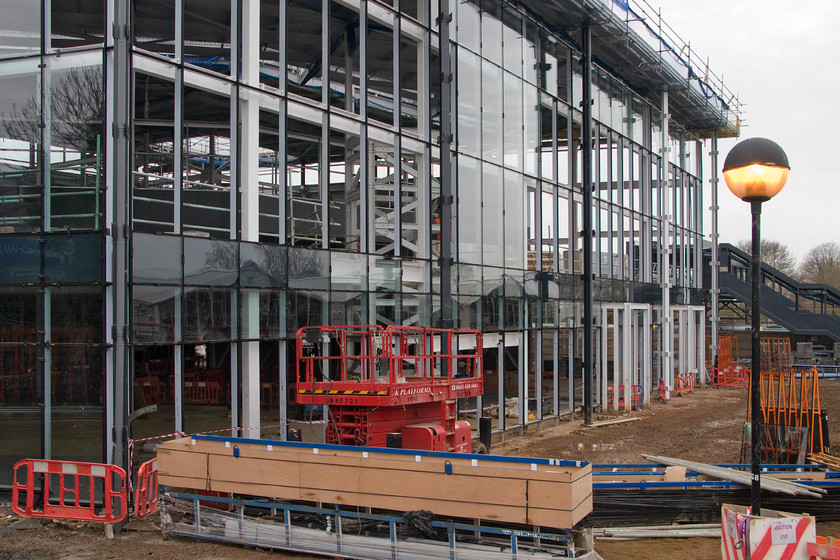 New station taking shape from ground floor level, Northampton station 
 Whilst the other side of Northampton's new station is clad with various coloured panels the side that faces the car park is almost completely glazed from top to bottom. It will afford lots of natural light to stream into the station with the main concourse being at first-floor level. In this view, the first of the vast double glazed panels have been applied to the framework. I suspect that this side of the station will age better to the eye than the clad sides with their brightly coloured panels that will go out of fashion more quickly than plain glass. 
 Keywords: New station taking shape from ground floor level Northampton station