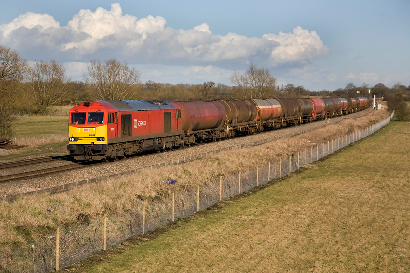 60039, 13.00 Theale-Robeston (6B33), Ashbury crossing SU246878 
 60039 plods along the down GWML with daily 13.00 Theale to Robeston empty tanks. It had been held in the Challow loops to allow the passage of faster express trains until control found a gap sufficiently large to allow it to continue westwards. The train would be held at Swindon again until it would be allowed to proceed for South Wales along the Badminton line from Wootton Bassett Junction where there is no access to any loops until Chipping Sodbury. 
 Keywords: 60039 13.00 Theale-Robeston 6B33 Ashbury crossing SU246878