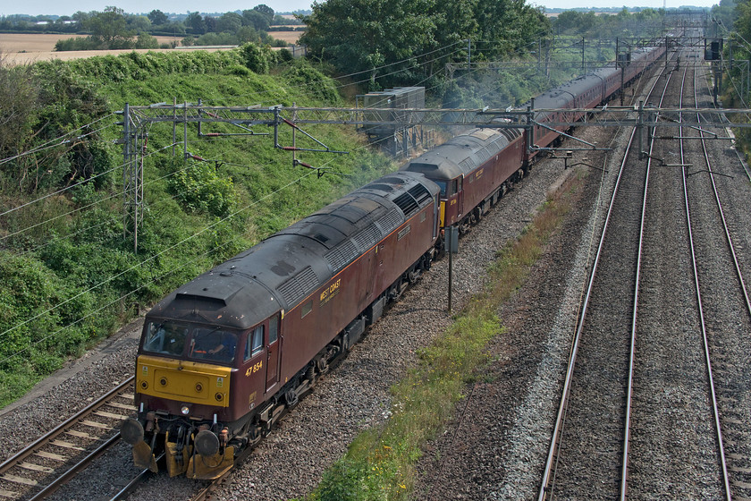 47854 & 57316, 12.23 London Euston-Chester ECS (5Z89, RT), Victoria bridge 
 A study of train photography in drabness! West Coast Railways livery looks incredibly dull in every condition, even in bright summer sunshine that can lift most trains from their background. 47854 'Diamond Jubilee' and 57316 lead the 12.23 Euston to Chester ECS trip running as 5Z89 through the hot Northamptonshire countryside just south of Roade. The train had operated yesterday's 'Cumbrian Mountain Express' charter and was being taken to Chester ready to work 'The Dalesman' charter on Tuesday. 
 Keywords: 47854 57316 12.23 London Euston-Chester ECS 5Z89 Victoria bridge WCR West Coast Railways 'Diamond Jubilee'