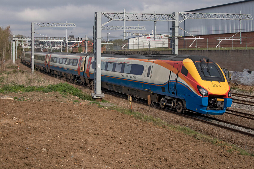 222015, EM 08.47 London St. Pancras-Corby (1M08, RT), Irthlingborough Road bridge 
 222015 '175 Years of Derby's Railways 1839 - 2014' slows for its stop at Wellingborough station forming the 1M08 08.47 St. Pancras to Corby train. The photograph is taken from the approach to the Irthlingborough Road overbridge. However, do not be fooled into thinking that looks to be a good spot as without a ladder or a flip-out camera screen it is difficult to get a decent image. In addition, the spot is a little dangerous as there is no pavement and the road is busy with trucks, van and cars exiting and entering the large Leyland industrial park that can be seen in the background. 
 Keywords: 222015 08.47 London St. Pancras-Corby 1M08 Irthlingborough Road bridge EMR East Midlands Railway Meridian 175 Years of Derby's Railways 1839 - 2014