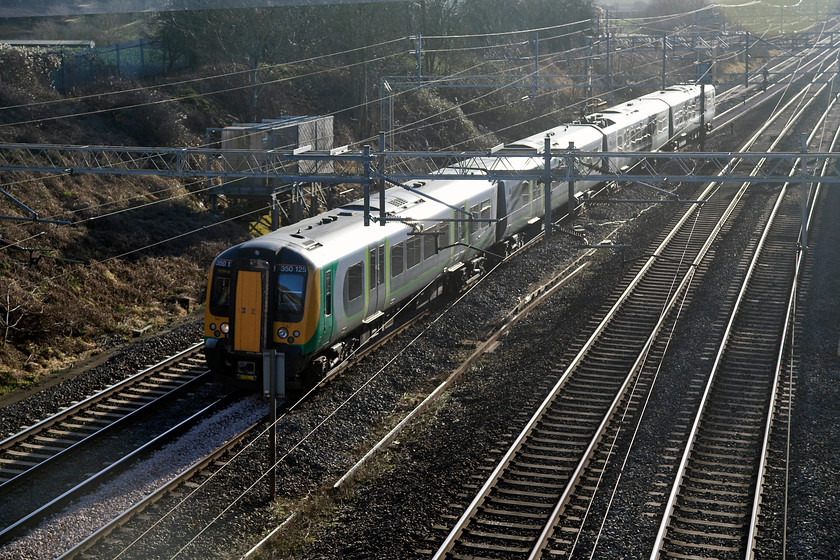 350125, LN-09.49 London Euston-Birmingham New Street (1W07, 2L), Victoria Bridge 
 350125 travels on the down slow line of the WCML past Victoria Bridge near Roade forming the 09.49 London Euston to Birmingham New Street. This shot is heavily back-lit but I like the effect of the sun bouncing off the roof, the sides and the face of the tracks. 
 Keywords: 350125 1W07 Victoria Bridge WCML Roade