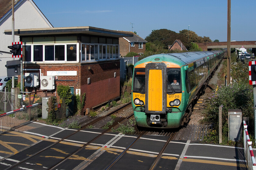 377213, SN 15.16 London Victoria-Littlehampton (1H38, 2L), Lancing level crossing 
 The 15.16 London Victoria to Littlehampton 'fast' service passes Lancing station at line speed worked by 377213. It is passing the sixty-year-old signal box located adjacent to the town's busy level crossing. Notice that the box still wears its somewhat faded but recognisable Network South East sign. 
 Keywords: 377213 15.16 London Victoria-Littlehampton 1H38 Lancing level crossing Sothern Electrostar