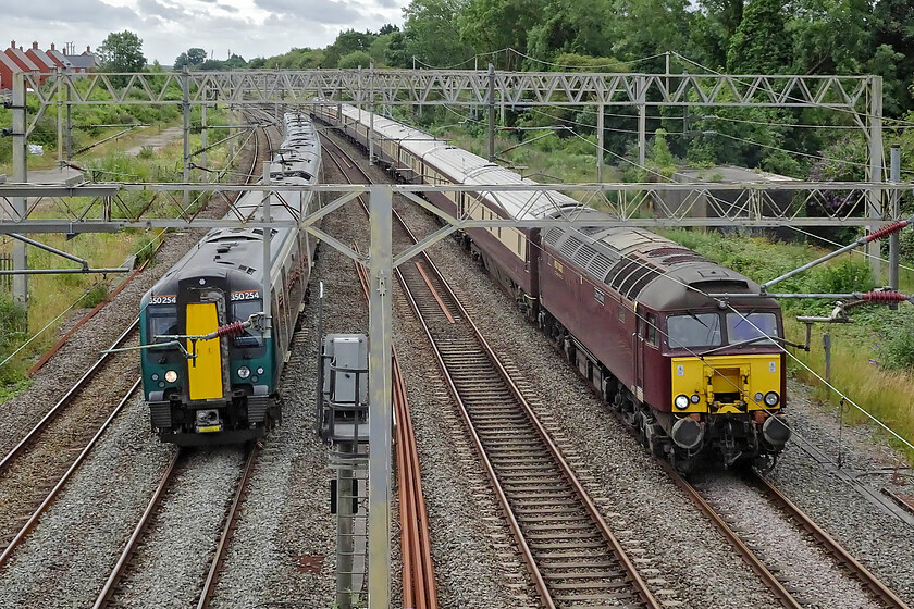 350254, LN 08.53 London Euston-Crewe (2U29, 42L) & 57314, 09.03 London Euston-Milton Keynes Central (via Rugby) (1Z73, 13L), site of Roade station 
 Appearances can be deceiving! It may look as if I have struck it lucky at Roade capturing two trains running side by side however, 350254 had been stationary at the signal in front of it for some time and would not move for another twenty minutes or so. The cause of the delay appeared to be a problem handing back the track through Northampton after an overnight possession as this was the first down train of the day, the 08.53 Euston to Crewe service. Of more interest is 57314 'Conwy Castle' leading the 09.03 Euston to Milton Keynes, via a reversal at Rugby, Grand Prix special charter. Passengers aboard the charter were tucking into their champaign breakfasts before being taken by bus from Milton Keynes to enjoy a day at the British Grand Prix. 
 Keywords: 350254 08.53 London Euston-Crewe 2U29 57314 09.03 London Euston-Milton Keynes Central via Rugby 1Z73 site of Roade station London Northwestern West Coast railways Conwy Castle