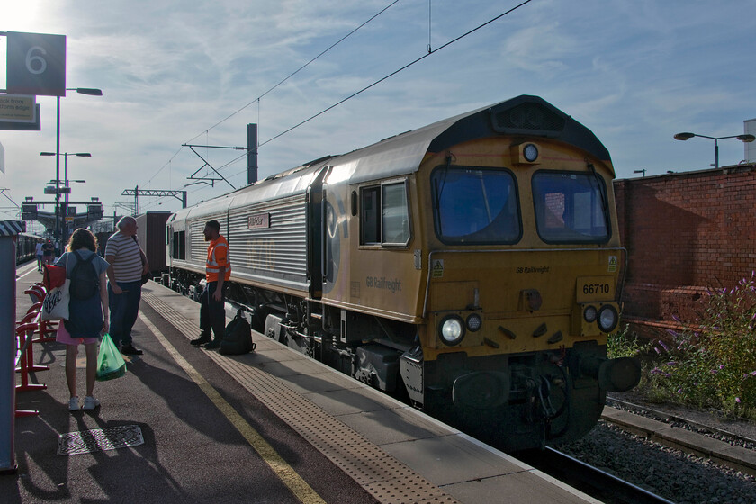 66710, 15.04 Birch Coppice-London Gateway (4L68, 33L), Rugby station 
 On arrival at Rugby station on our return journey the 4L68 15.05 Birch Coppice to London Gateway was standing at platform six. With the driver standing talking to an enthusiast on the platform in the evening sunshine 66710 'Phil Packer' rests prior to continuing its journey southwards. 
 Keywords: 66710 15.04 Birch Coppice-London Gateway 4L68 Rugby station GBRf Phil Packer