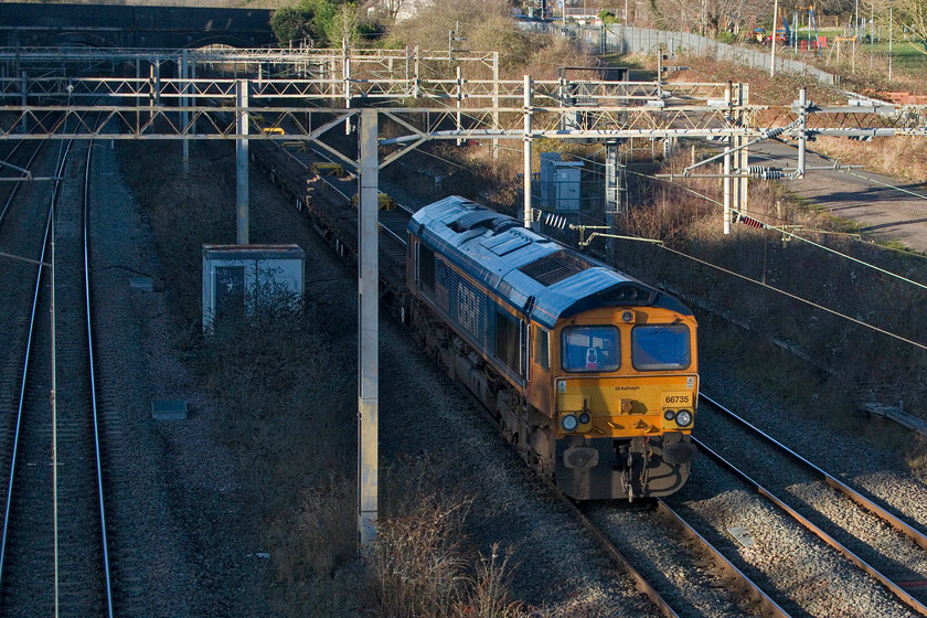 66735, 08.05 Ledburn Junction-Bescot Yard (6G60, 316L), site of Roade station 
 Just about to plunge into the darkness of Roade cutting the incredibly late 6G60 08.05 Ledburn Junction to Bescot Yard used ballast train is brought up at the rear by 66735 'Peterborough United'. The train arrived some five hours late into Bescot no doubt with the train crew in for a hefty overtime payment! 
 Keywords: 66735 08.05 Ledburn Junction-Bescot Yard 6G60 site of Roade station Peterborough United