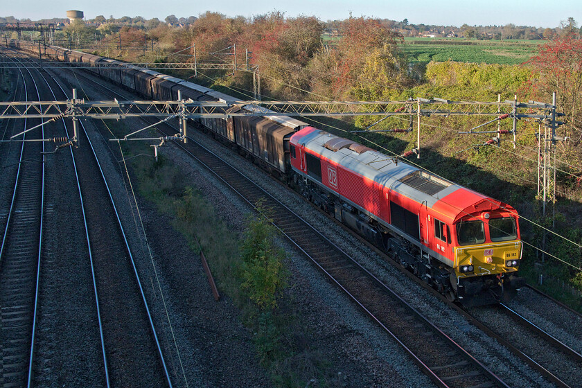 66182, 14.05 DIRFT-Dollands Moor (6O67, 7L), Victoria bridge 
 Just managing to catch the low-angled sunshine on this extremely warm November afternoon 66182 heads south between Roade and Ashton leading the daily 6O67 14.06 Daventry (DIRFT) to Dollands Moor empty ferrywagons. This is the balancing service to the bottled water train that comes in from the continent arriving at DIRFT earlier in the day. The empty stock seen here was yesterday's inbound loaded train. 
 Keywords: 66182 14.05 DIRFT-Dollands Moor 6O67 Victoria bridge DB